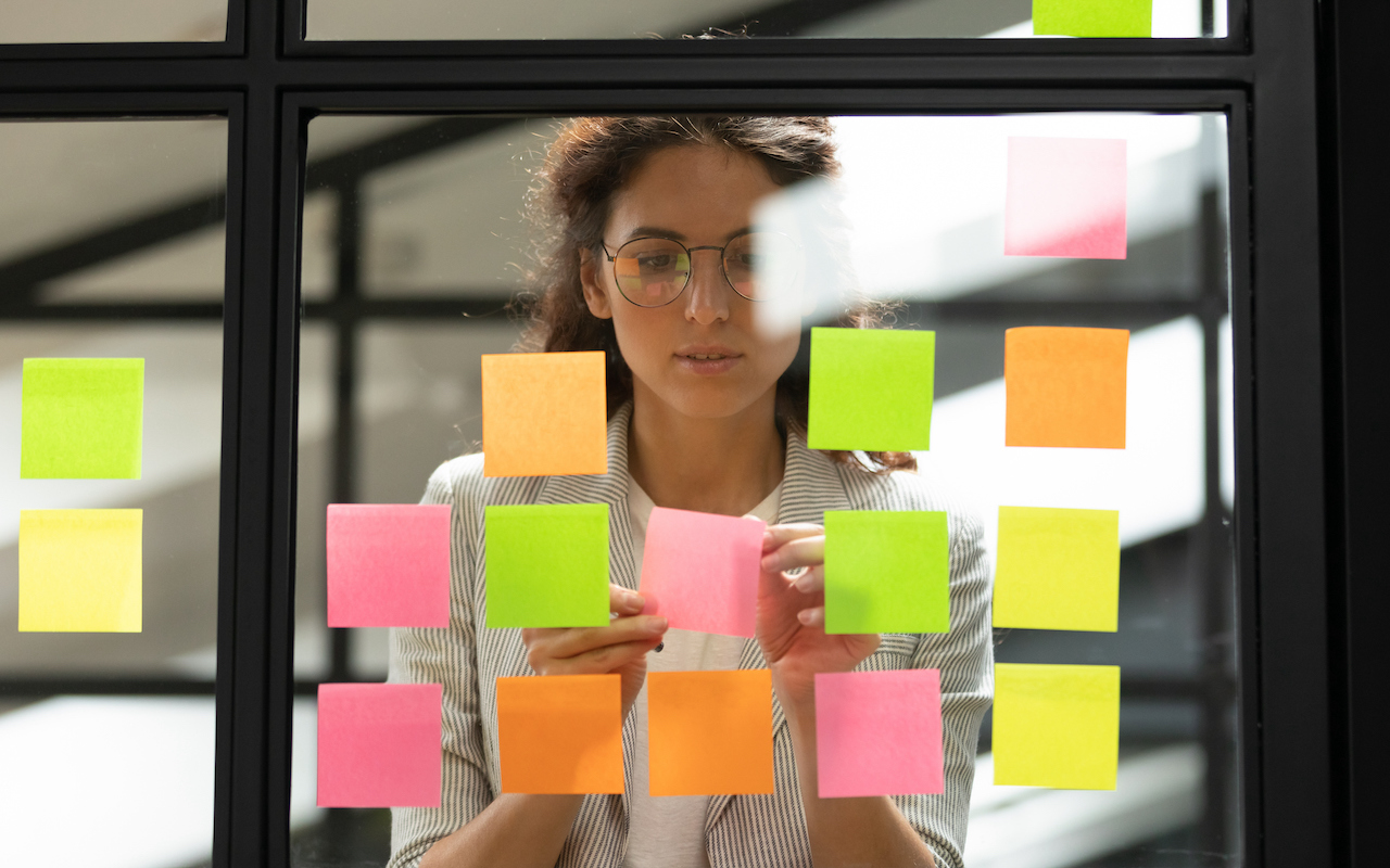 Businesswoman creating to-do list using multicolored sticky notes